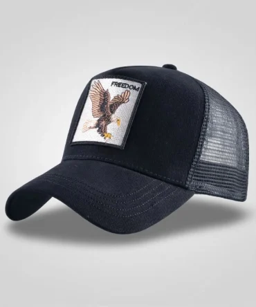 Black trucker hat with embroidered bald eagle patch and "FREEDOM" text, mesh back, side view.
