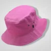 A vibrant pink corduroy bucket hat with small dark eyelets and a black tag on the side, perfect for outdoor summer wear.