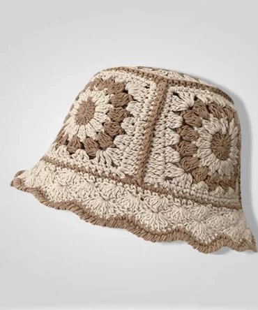 "Crochet bucket hat in beige and brown, featuring a floral granny square pattern, isolated on a light gray background. Ideal for bohemian or casual fashion."
